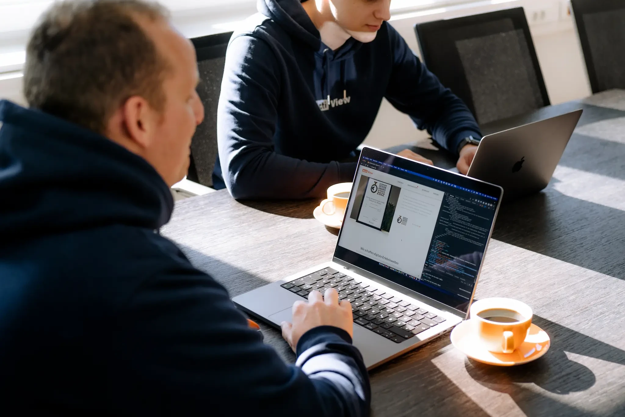 Zwei Frontend-Entwickler bei der Abstimmung im Besprechungsraum der Actiview GmbH