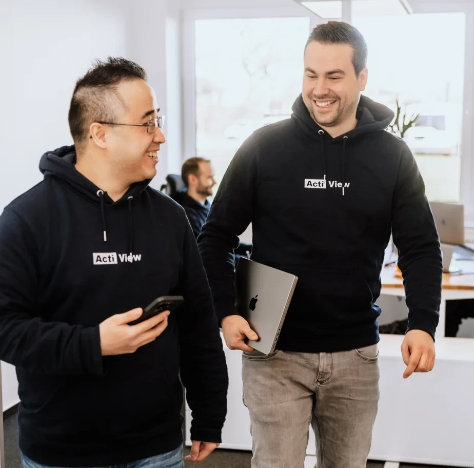 Zwei Kollegen verlassen zusammen ein Büro und machen sich gemeinsam auf dem Weg zum Business-Meeting.